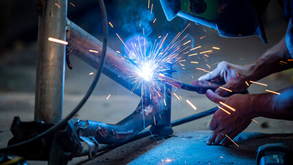 Wall Mural - Welding of steel, sparking, not wearing gloves, light colored like fireworks.