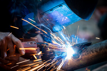 Wall Mural - Welding of steel, sparking, not wearing gloves, light colored like fireworks.