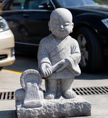 Wall Mural - Stone figurine of standing little monk in courtyard of Qibao Temple, a Buddhist monastery in Qibao Old Town, Minhang, Shanghai, China.