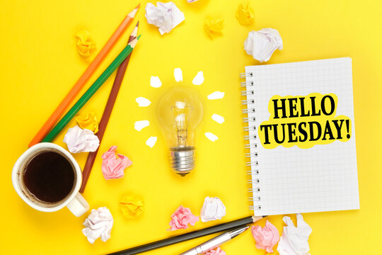 On a yellow background, a cup of coffee, a light bulb, pencils, a notebook with the inscription - HELLO TUESDAY