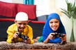 © WESTOCK - Two Muslim sibling kids playing videogame using joystick while lying on floor at home - Concept of children unhealthy playing position and gaming addiction