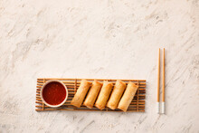 Tasty Fried Spring Rolls And Sauce On Light Background