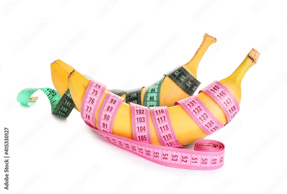Ripe bananas and measuring tape on white background. Weight loss concept