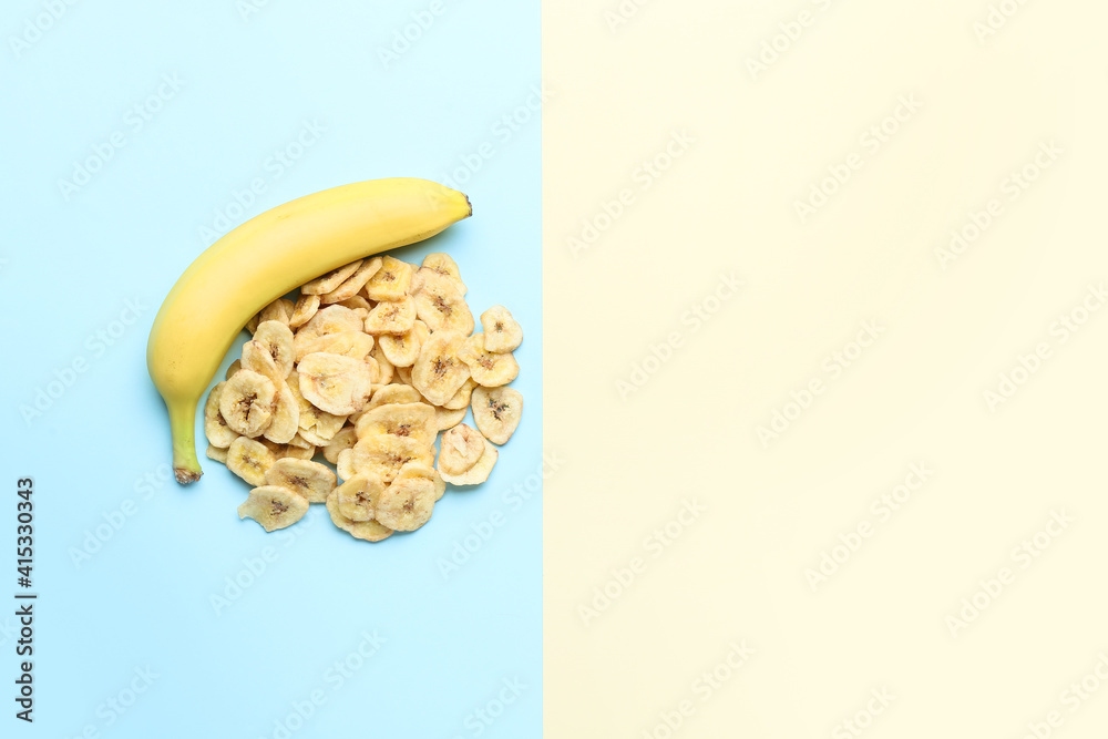 Fresh banana and crispy chips on color background