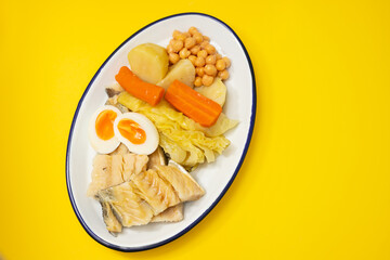 boiled cod fish with boiled vegetables and egg on white dish