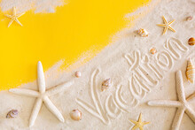Holiday Word On Beach Sand Surrounded By Shells And Starfish. The Concept Of Vacation, Resort And Beach Vacation. Yellow Background With Copy Space For Text.