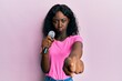 © Krakenimages.com - Beautiful african young woman singing song using microphone pointing to camera depressed and worry for distress, crying angry and afraid. sad expression.