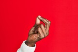 Fototapeta  - Arm and hand of african american black young man over red isolated background snapping fingers for success, easy and click symbol gesture with hand
