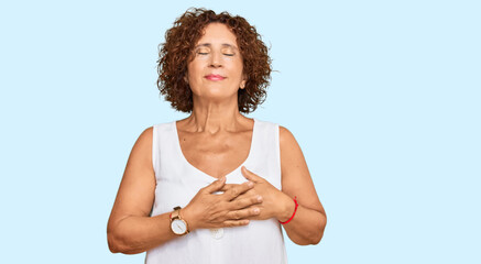 Poster - Beautiful middle age mature woman wearing casual white shirt smiling with hands on chest with closed eyes and grateful gesture on face. health concept.