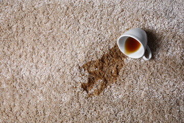 Poster - Overturned cup and spilled tea on beige carpet, top view. Space for text