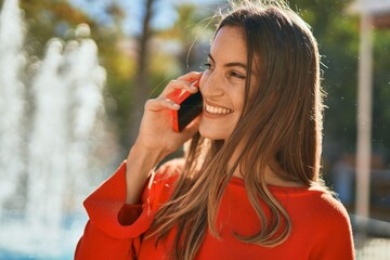 Young hispanic woman smiling happy talking on the smartphone at the city.