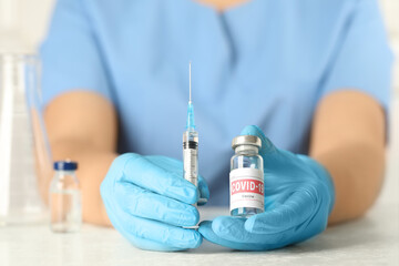 Wall Mural - Doctor with coronavirus vaccine at table in laboratory, closeup