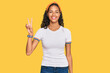 © Krakenimages.com - Young african american girl wearing casual clothes smiling looking to the camera showing fingers doing victory sign. number two.
