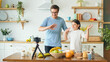 © alex_marina - A Father with a Cute Daughter is Blogging About Cooking. Video Blog About Healthy Eating. A Father with a Child is Watching an Online Video Blog. A Father Teaches His Daughter to Cook.