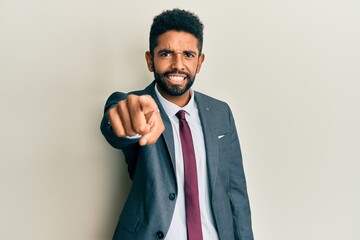 Canvas Print - Handsome hispanic man with beard wearing business suit and tie pointing displeased and frustrated to the camera, angry and furious with you