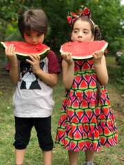 two children eating watermelon