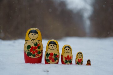 Wall Mural - A row of nesting dolls in a snowy forest.