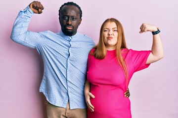 Sticker - Young interracial couple expecting a baby, touching pregnant belly strong person showing arm muscle, confident and proud of power