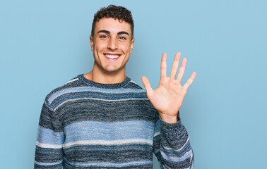 Hispanic young man wearing casual clothes showing and pointing up with fingers number five while smiling confident and happy.