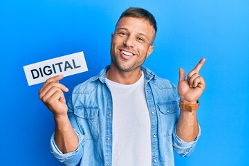 Canvas Print - Handsome muscle man holding digital word on paper smiling happy pointing with hand and finger to the side