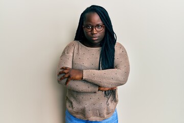 Sticker - Young black woman with braids wearing casual clothes and glasses skeptic and nervous, disapproving expression on face with crossed arms. negative person.