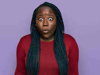 Wall Mural - Young black woman with braids wearing casual clothes scared and amazed with open mouth for surprise, disbelief face