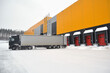 Delivery of goods by truck to a warehouse complex in winter.