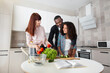 © sofiko14 - Family cooking concept. Handsome afro american father teaching his cute tenn daughter chopping of vegetables. Smiling pretty caucasian mom holds tomatoes looking at her husband and daughter