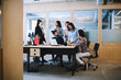 Colleagues brainstorming while working in modern workspace