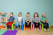 © oksix - Children are sitting on the colorful chairs in the kindergarten