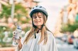 © Krakenimages.com - Caucasian sporty teenager girl wearing bike helmet and drinking bottle of water at the city.