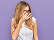 © Krakenimages.com - Beautiful young caucasian girl wearing casual clothes and glasses smelling something stinky and disgusting, intolerable smell, holding breath with fingers on nose. bad smell