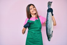 Beautiful Caucasian Woman Fishmonger Selling Fresh Raw Salmon Smiling Happy Pointing With Hand And Finger