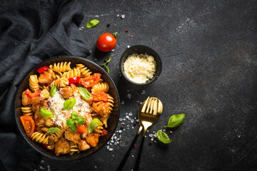 Wall Mural - Pasta chicken with vegetables. Served with parmesan. Top view at black table.