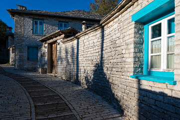 Wall Mural - Stone houses of traditional architecture and cobble-stone narrow street in Papigo in Epirus, Greece