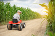 © Jacek - A farmer boy is driving a tractor through a corn field.
