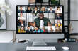 © Kateryna - Virtual business meeting, online briefing, brainstorm. A computer monitor is on the desktop, on the screen is many different multiracial business partners gathered in a video conference