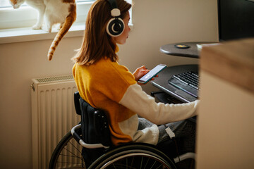 Wall Mural - Disabled woman using technology while sitting in wheelchair at home