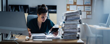 Young Businesswoman Working At Office With Stack Of Folders