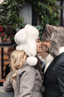 © Yury - Fashion couple of lovers embracing, standing on winter street in snowy weather, man and woman wear fur hat and warm wool coat. St. Valentines Day, Christmas holidays concept.