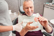 Dentist showing to senior patient teeth dentures