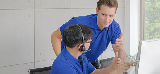 Multi ethnic successful customer service business teamwork banner concept. Happy call center male staff giving thumb up each other for celebrate achievement. Selective focus and copy space.