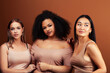 © iordani - young pretty asian, caucasian, afro woman posing cheerful together on brown background, lifestyle diverse nationality people concept
