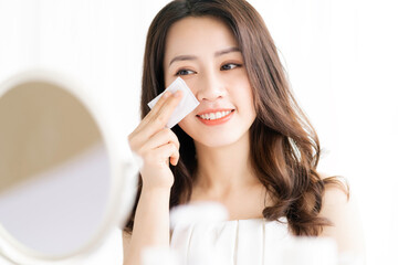 Asian woman sitting makeup in front of mirror