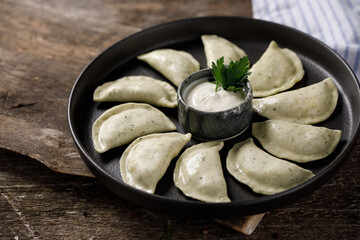 Appetizing traditional Russian dumplings made by hand with delicious curd filling. Still life on a wooden board. Close-up.