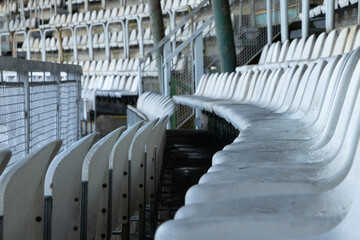 Wall Mural - Selective focus shot of old empty white bleachers in a stadium