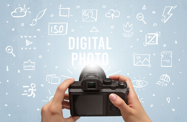 Hand taking picture with digital camera and DIGITAL PHOTO inscription, camera settings concept