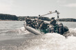 © andy_gin - Group of military fighters on a boat with a flasher are chasing pirates. The concept of sea robberies, piracy, poaching.