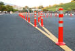 Closeup of traffic regulation poles on asphalt road in public park with natural background in the evening. 