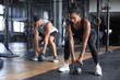 © ty - Fit and muscular couple focused on lifting a dumbbell during an exercise class in a gym.